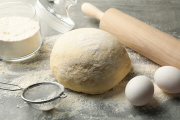 Fototapeta na wymiar Concept for baking with dough on gray background