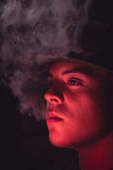 young man smoking marijuana, smoking tobacco, red lighting