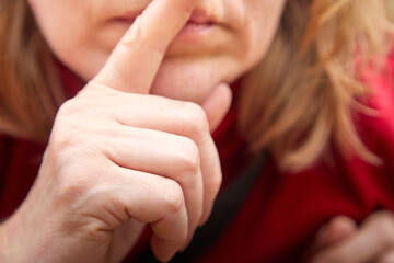 Finger of a girl or middle aged woman showing sign and attracting attention