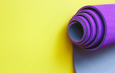 Bright purple yoga mat on a yellow background