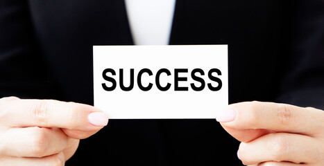 The businessman puts in his jacket pocket a business card with the inscription SUCCESS.