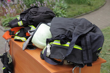 Rescuer firefighter protective rescue equipment gear close up on table outdoor - fire helmet, fireman's robe, gloves