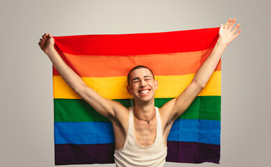 Smiling transgender man with pride flag