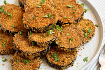 Homemade Garlic Parmesan Baked Eggplant on a plate, low angle view. Close-up.