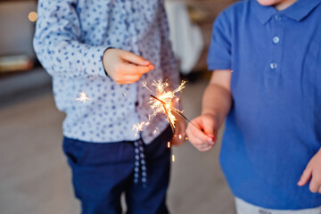 Selective focus. Children hold a Sparkler, close-up. Sparkler and sparks Macro photo festive bokeh background, magical atmosphere for Christmas and New year