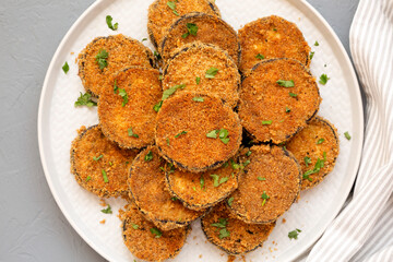 Homemade Garlic Parmesan Baked Eggplant on a plate over gray background, top view. Flat lay, overhead, from above.