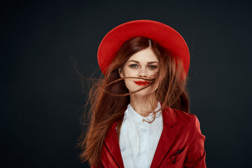 Pretty woman with red lips hat on her head jacket elegant style charm dark isolated background
