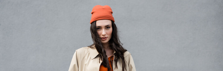 website header of stylish woman in trench coat and beanie hat