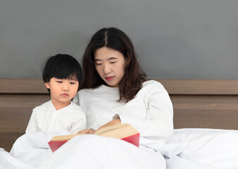 Mother who gets up early in bed and cultivates her daughter's interest in reading