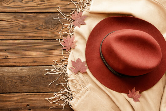 Autumn female fashion flat lay with felt hat, pashmina shawl and dry maple leaves