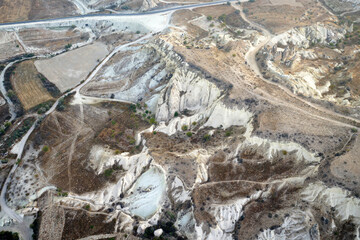 Natural landscape view from hot air balloon ride and tour in Kapadokya Goreme valley, semi-arid region known for its distinctive fairy chimneys, tall, cone-shaped rock formation- Cappadocia, Turkey
