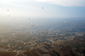 Colorful hot air balloon ride and tour in Goreme valley, semi-arid region in central Turkey known for its distinctive fairy chimneys, tall, cone-shaped rock formation- Cappadocia, Turkey