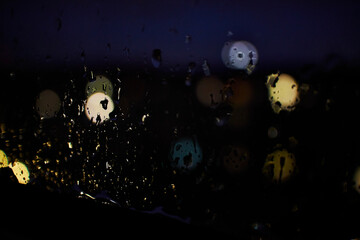 Raindrops on a window and blurred lights