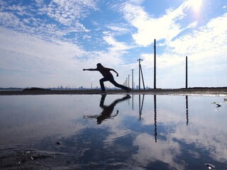 電柱のある海で見えない敵に向かってパンチしている人