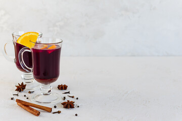 Mulled wine with cinnamon, anise, cloves and orange on a light background. Horizontal orientation, copy space.