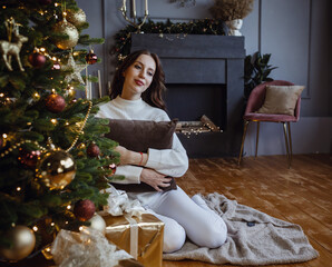 Beauty woman near Christmas tree with presents. New Year Concept.