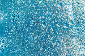 Blue water drops on the glass, abstract background, large and small drops. Space for text