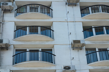 Metal summer balconies with air conditioner coolers on the facade of the hotel.