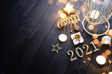 Burning lantern with christmas decoration on black wooden table with copy space.