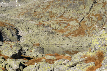 Lake in mountains. Pond in Valley of Five Spis Lakes surrounded by rocky summits, High Tatra Mountains, Slovakia.