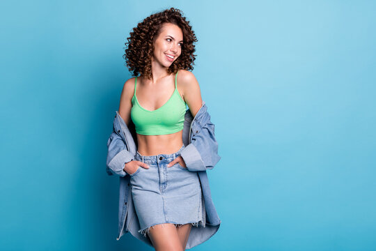 Photo adorable slender shiny lady model perfect shape look empty space hands pockets clothes brand advert wear green top denim off shoulders shirt skirt isolated pastel blue color background