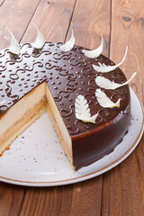 Cut chocolate cake on plate on wooden table