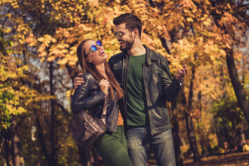 Photo of romantic positive two students girl guy tell funny joke in orange town forest park wear sunglass jacket