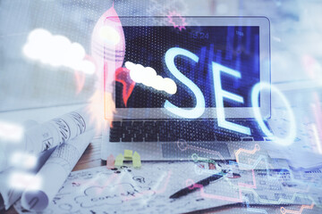 Multi exposure of table with computer and seo drawing hologram. Search optimization concept.