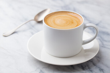 Coffee, espresso in white cup. Marble background. Close up.