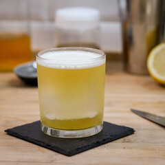 Tea Time Cocktail in thin rock glass on wood table with ingredients
