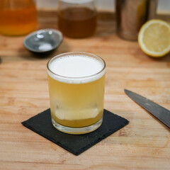 Tea Time Cocktail in thin rock glass on wood table with ingredients