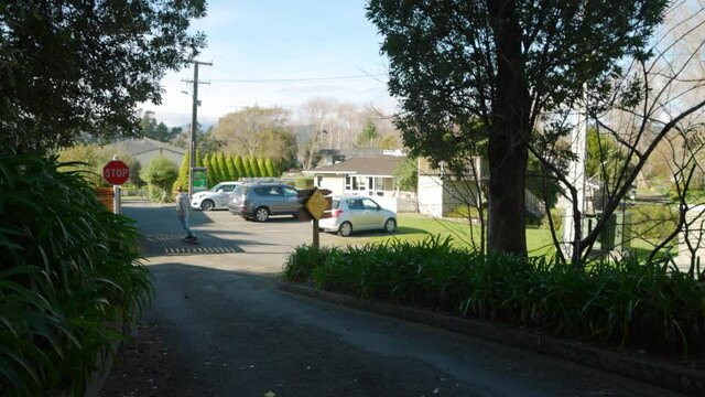 A tilting and panning video of a man riding past the camera on a longboard skateboard