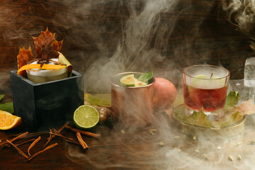 Autumn fruit alcoholic cocktails with apple, lime, orange and cinnamon on the table in restaurant