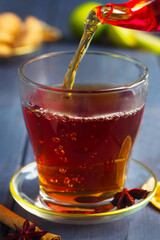 black tea is poured into a glass from a teapot