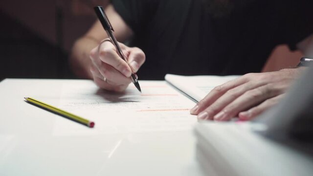 Man Studying And Underlining Important Text On The Reviewer Using Ballpen. - close up