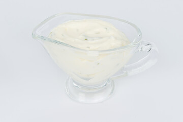 Mayonnaise in a transparent gravy boat shot on a white background