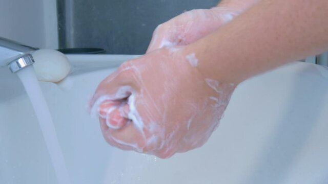 Washing hands in the corona covid-19 pandemic with soap in the bathroom.
H&auml;nde waschen w&auml;hrend der Corona Covid-19 Pandemie im Badezimmer.