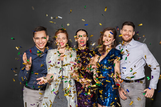 Celebration, People And Holidays Concept - Happy Friends At Party Under Golden Confetti Over Black Background