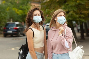 Two young best friends meeting on street wearing a face mask to protection by Coronavirus, Covid-19 and stay security distant.