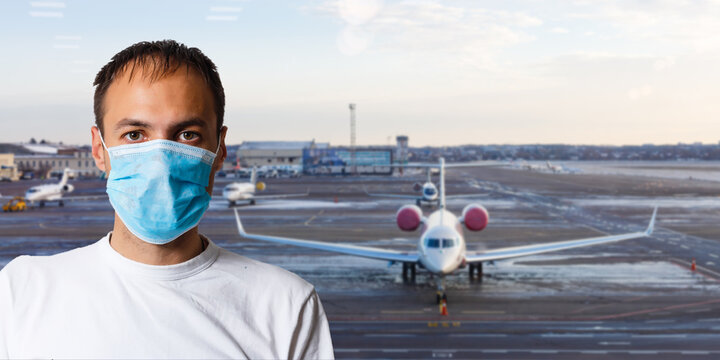 Man Wearing A Mask For Prevent Virus In International Airport Lounge With His Luggage. Protection Against Coronavirus And Gripp