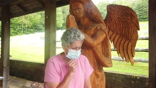 Very sad women wearing a mask looks to angel with hope