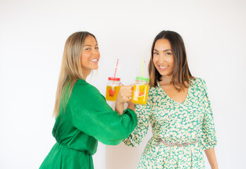 Women toasting with fruit juices while smiling