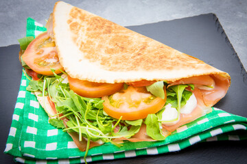 typical piadina romagnola with ham, cheese and rocket