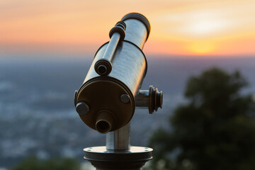 coin telescope at a view point at sunset
