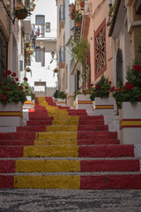 Street of the old town in the center of Calpe with the staircase painted with the colors of the Spanish flag, Alicante. Spain