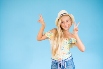 Blonde girl with a hat making the victory gesture