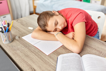 Fototapeta na wymiar children, education and learning concept - tired teenage student girl sleeping on table at home