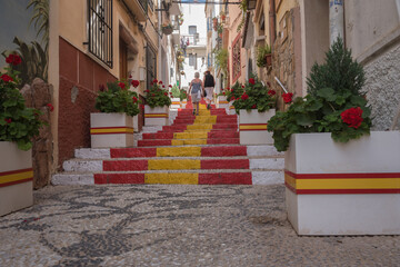 Street of the old town in the center of Calpe with the staircase painted with the colors of the...