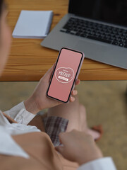 Female using mock up smartphone while sitting at worktable