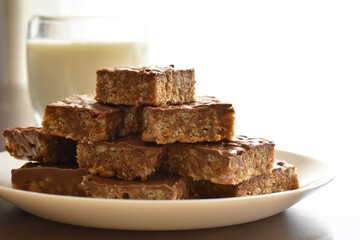 Chocolate rice crispy slices on a white plate.  Copy space is on the right side.